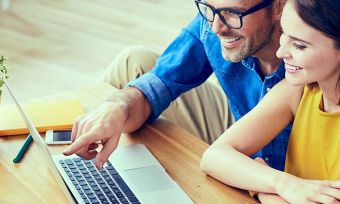 Happy couple reading something on their computer