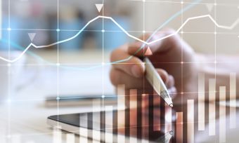 close up of somebody's hand and tablet while investing online with stock graph overlay